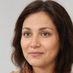 Joyful white adult female with long  brown hair and brown eyes