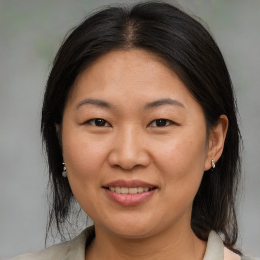 Joyful asian adult female with medium  brown hair and brown eyes