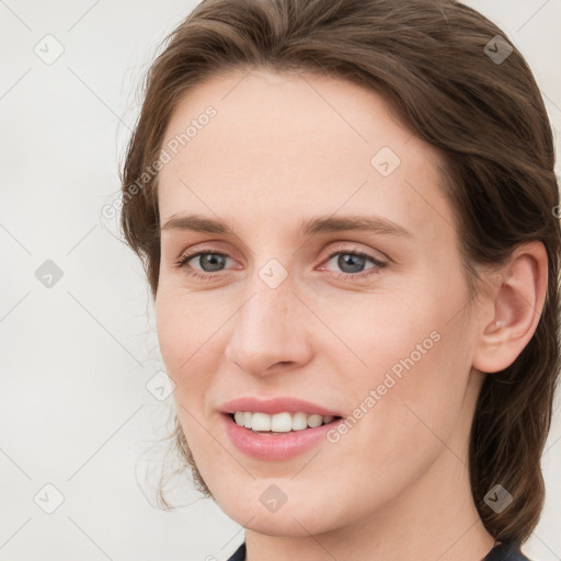 Joyful white young-adult female with medium  brown hair and blue eyes