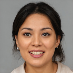 Joyful latino young-adult female with medium  brown hair and brown eyes