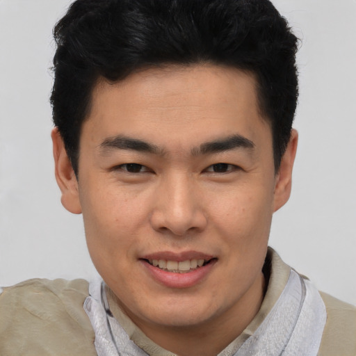 Joyful asian young-adult male with short  black hair and brown eyes