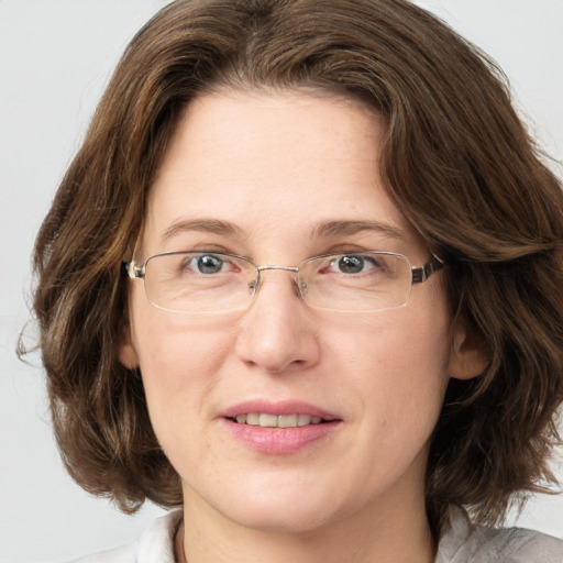 Joyful white adult female with medium  brown hair and grey eyes