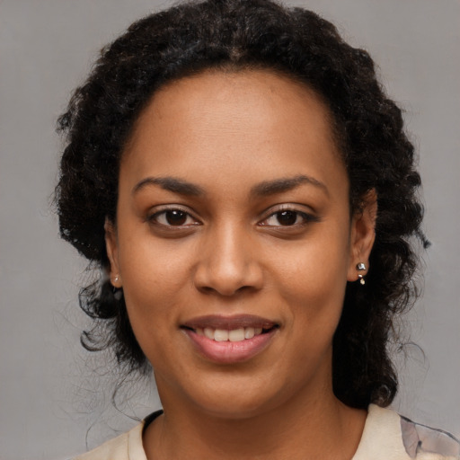 Joyful black young-adult female with long  brown hair and brown eyes
