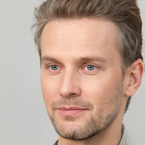 Joyful white adult male with short  brown hair and brown eyes