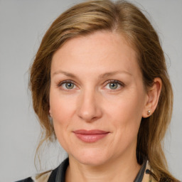 Joyful white adult female with medium  brown hair and blue eyes