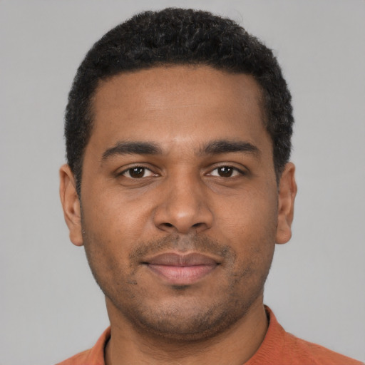 Joyful black young-adult male with short  black hair and brown eyes