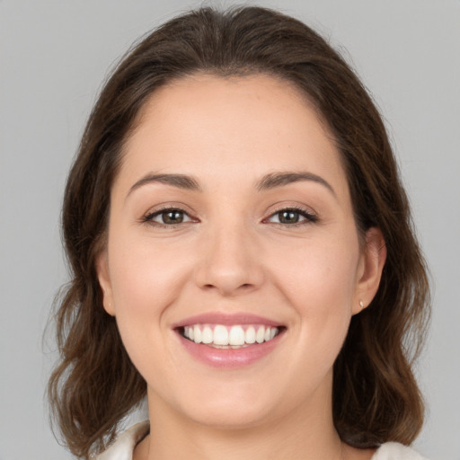 Joyful white young-adult female with medium  brown hair and brown eyes