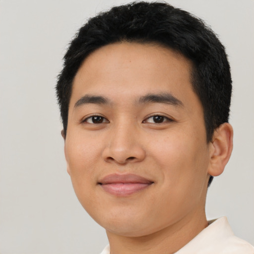 Joyful latino young-adult male with short  black hair and brown eyes