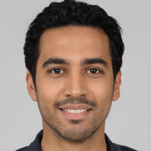 Joyful latino young-adult male with short  black hair and brown eyes