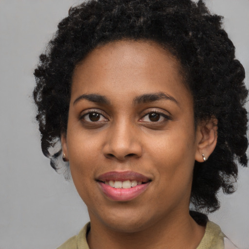 Joyful black young-adult female with short  black hair and brown eyes