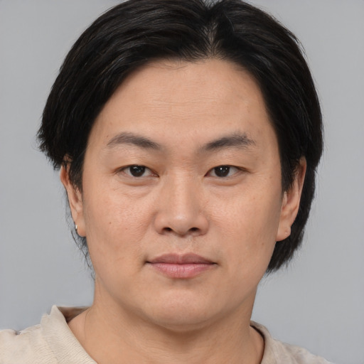 Joyful asian adult male with short  brown hair and brown eyes