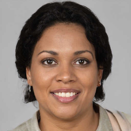 Joyful black adult female with medium  brown hair and brown eyes