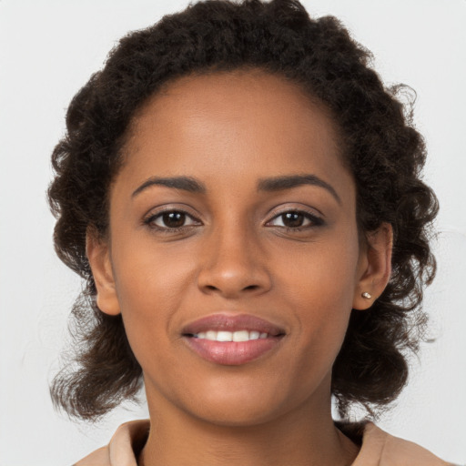 Joyful black young-adult female with long  brown hair and brown eyes