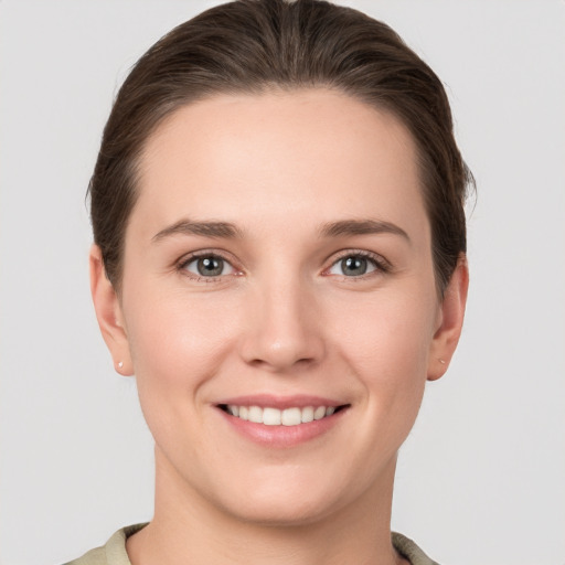 Joyful white young-adult female with short  brown hair and grey eyes