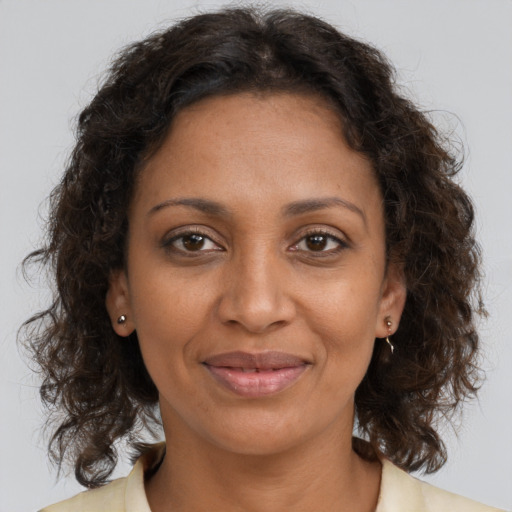 Joyful black adult female with medium  brown hair and brown eyes