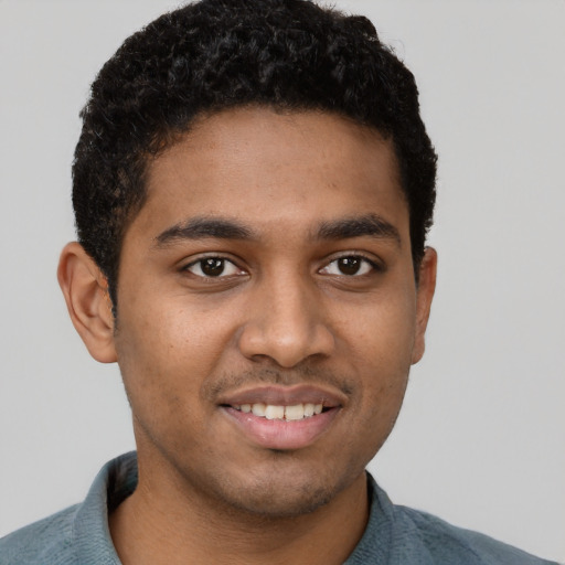 Joyful black young-adult male with short  brown hair and brown eyes