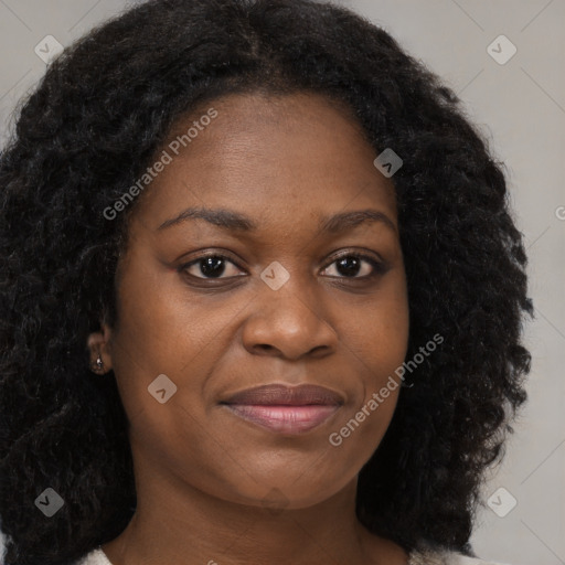 Joyful black young-adult female with long  brown hair and brown eyes