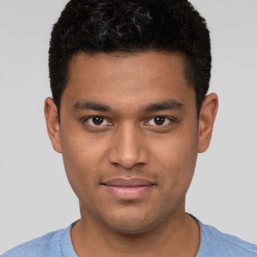Joyful black young-adult male with short  brown hair and brown eyes