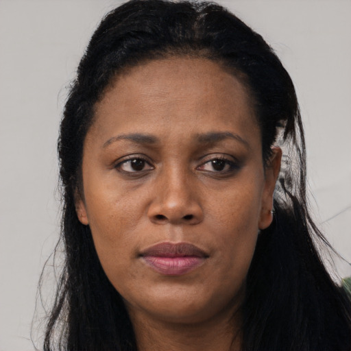 Joyful black adult female with long  black hair and brown eyes