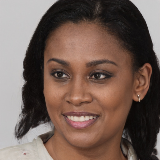 Joyful black young-adult female with medium  brown hair and brown eyes