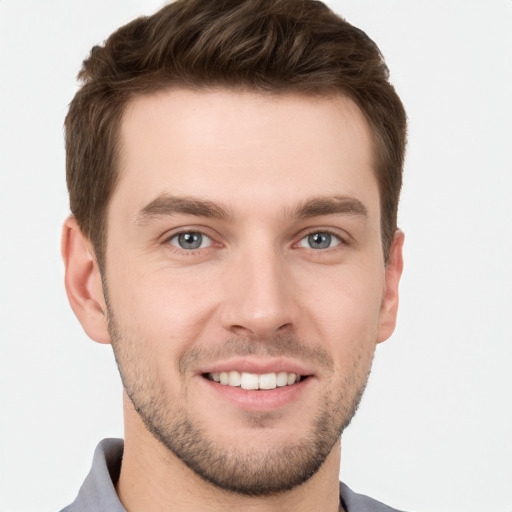 Joyful white young-adult male with short  brown hair and grey eyes