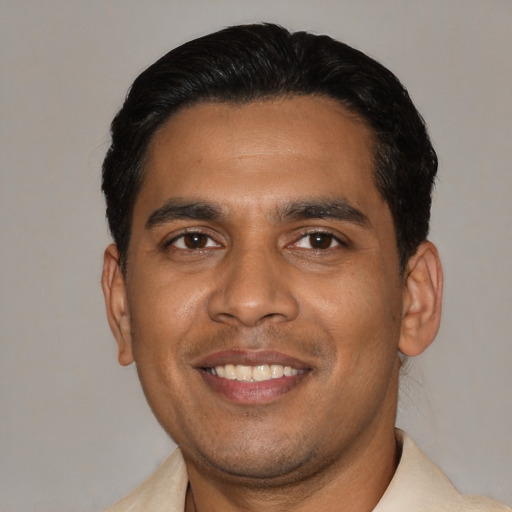 Joyful latino young-adult male with short  black hair and brown eyes