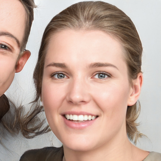 Joyful white young-adult female with medium  brown hair and grey eyes