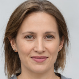 Joyful white adult female with medium  brown hair and grey eyes