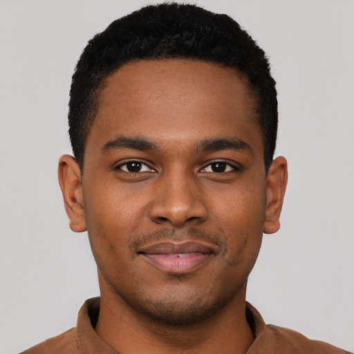 Joyful black young-adult male with short  black hair and brown eyes