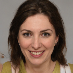 Joyful white adult female with medium  brown hair and brown eyes