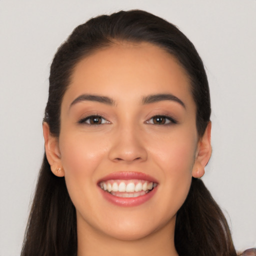 Joyful latino young-adult female with long  brown hair and brown eyes