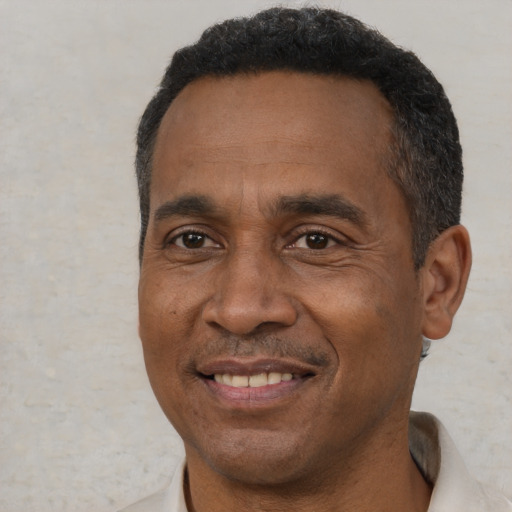Joyful black adult male with short  black hair and brown eyes