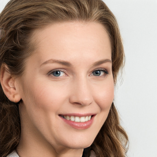 Joyful white young-adult female with long  brown hair and blue eyes