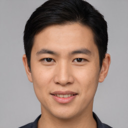 Joyful asian young-adult male with short  black hair and brown eyes