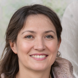 Joyful white adult female with medium  brown hair and grey eyes