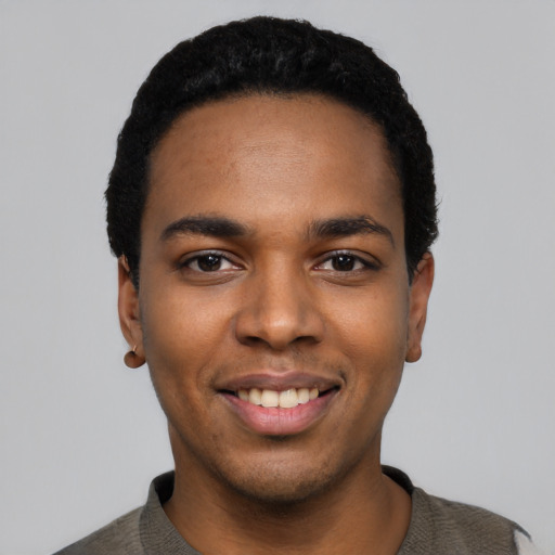 Joyful black young-adult male with short  black hair and brown eyes