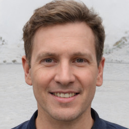 Joyful white adult male with short  brown hair and grey eyes