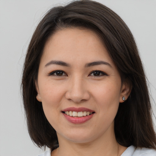 Joyful white young-adult female with long  brown hair and brown eyes