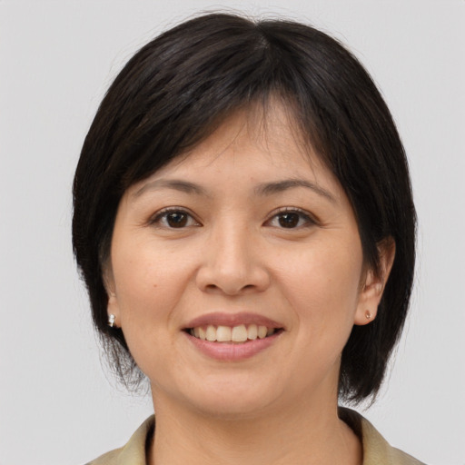 Joyful asian young-adult female with medium  brown hair and brown eyes