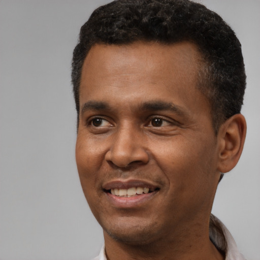 Joyful black young-adult male with short  black hair and brown eyes