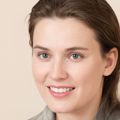 Joyful white young-adult female with medium  brown hair and grey eyes