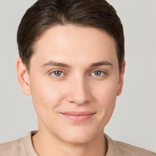 Joyful white young-adult male with short  brown hair and grey eyes