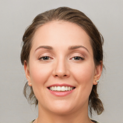 Joyful white young-adult female with medium  brown hair and grey eyes