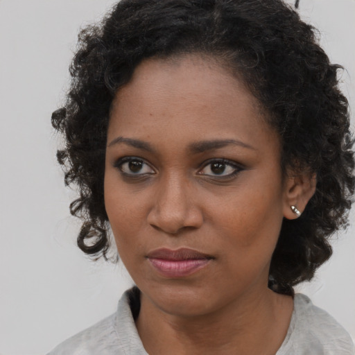 Joyful black young-adult female with medium  brown hair and brown eyes