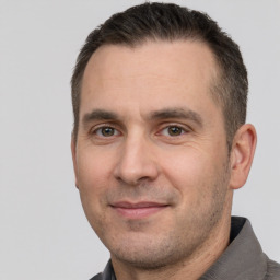 Joyful white adult male with short  brown hair and brown eyes