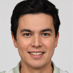 Joyful latino young-adult male with short  black hair and brown eyes