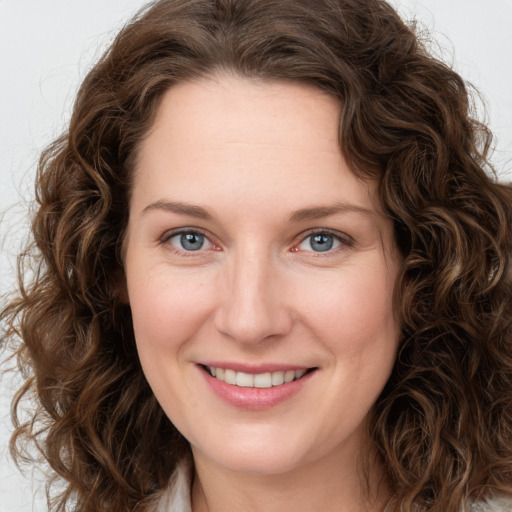 Joyful white young-adult female with long  brown hair and green eyes