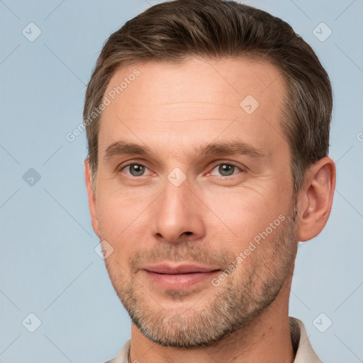 Joyful white adult male with short  brown hair and brown eyes