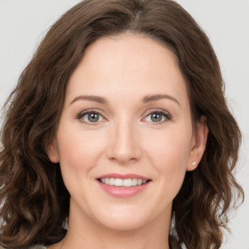 Joyful white young-adult female with long  brown hair and green eyes