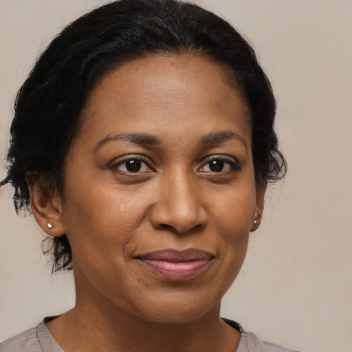 Joyful black adult female with medium  brown hair and brown eyes